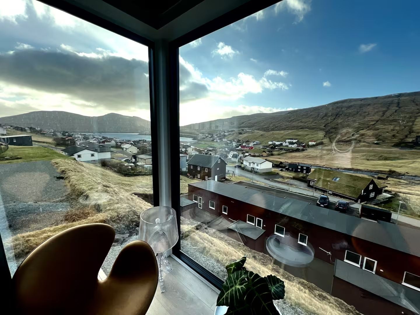 Una habitación con un ventanal grande que da a una ciudad y colinas.