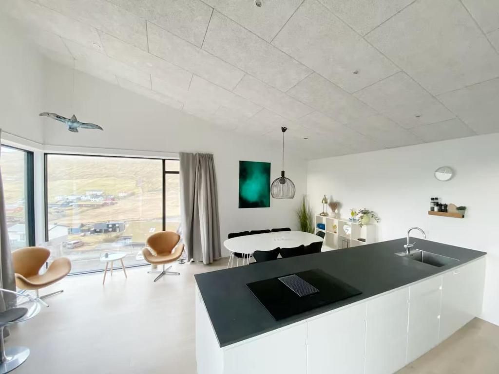Una cocina moderna con una isla grande, comedor y vistas al exterior.