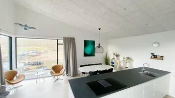 Una cocina moderna con una isla grande, comedor y vistas al exterior.