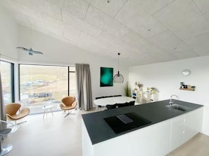 Una cocina moderna con una isla grande, comedor y vistas al exterior.