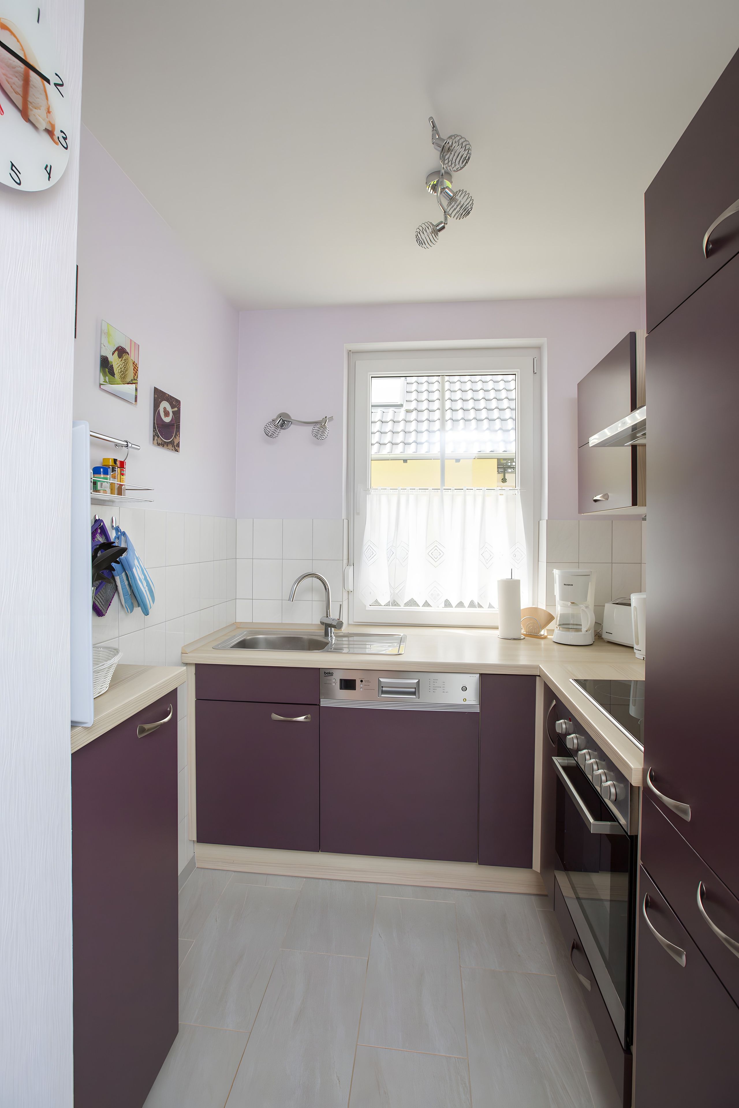 A compact kitchen with a sink, dishwasher, and oven.