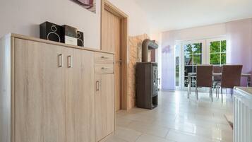 A modern kitchen with wooden cabinets, a built-in stove, and a dining area with a table and chairs.
