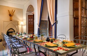 A dining area with a long table set for a meal, surrounded by chairs. - Angsana Riad Dar Si Said (Marrakech)