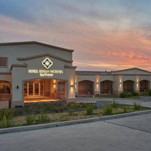 A hotel with a modern facade, a prominent logo, and a well-lit entrance.