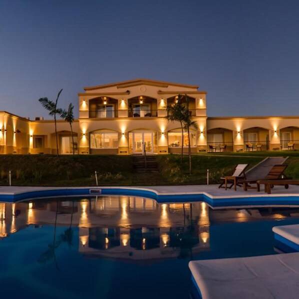 A two-story hotel with a swimming pool and lounge chairs. - Hotel Termas Victoria (Victoria)