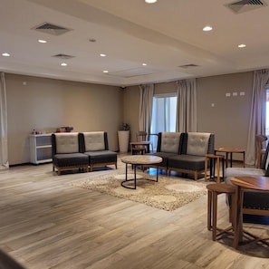 A modern living room with two sofas, a coffee table, and a small dining table.