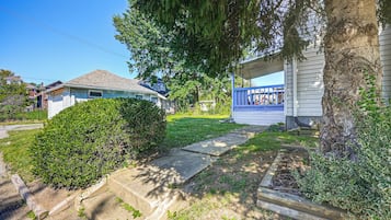 A residential property with a paved driveway, a covered porch, and a well-maintained lawn.