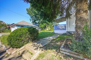 A residential property with a paved driveway, a covered porch, and a well-maintained lawn.