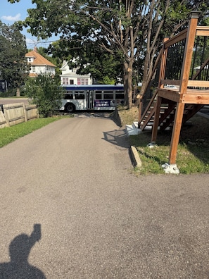 A paved road leading to a bus stop with a wooden fence and a staircase. - Charming 2-bedroom Downstairs in fantastic Saint Paul with AC (Saint Paul)