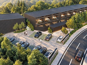 A modern multi-story parking garage with a covered walkway and a landscaped area.