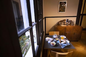 A dining area with a table set for breakfast, including plates, cups, and a fruit bowl. - New Voga Hotel Boutique (Valparaiso)