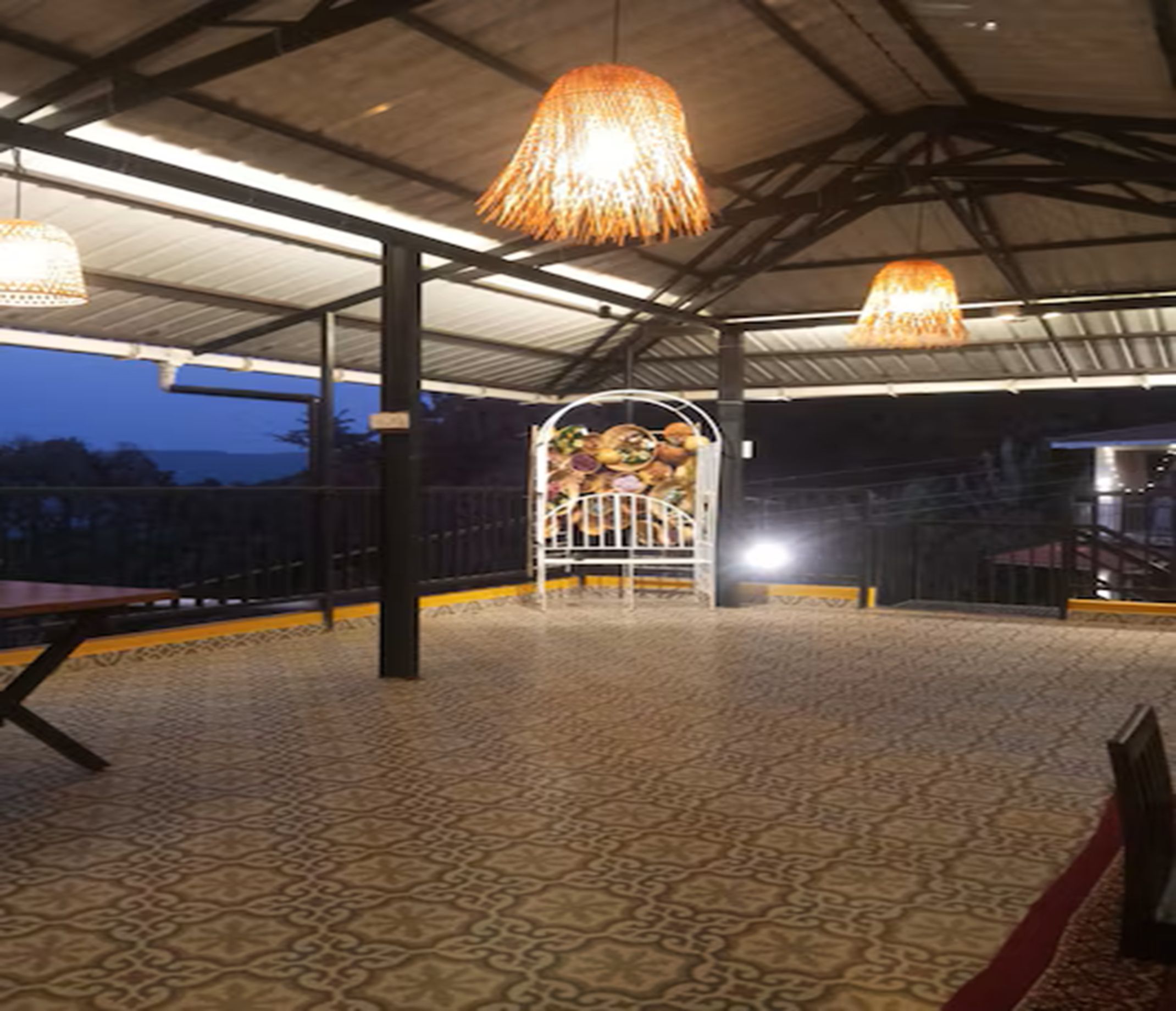 An indoor area with a patterned floor, metal railings, and hanging lamps.