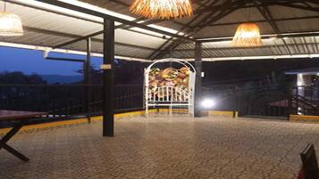 An indoor area with a patterned floor, metal railings, and hanging lamps.
