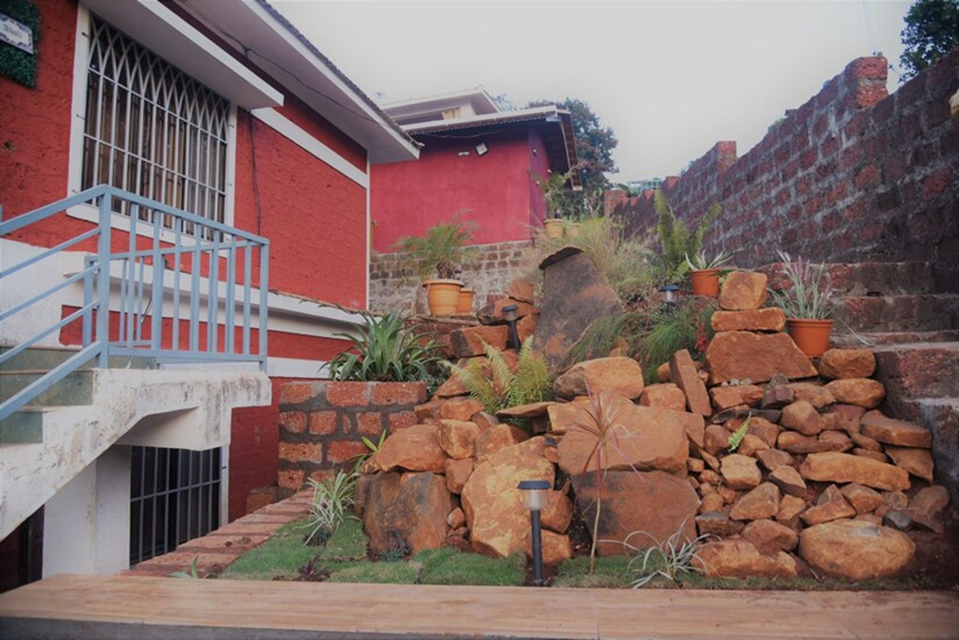 Um edifício vermelho com parede de pedra e escadaria de metal.