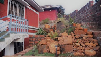 Um edifício vermelho com parede de pedra e escadaria de metal.