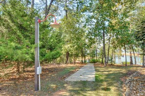 A pathway leading to a body of water, surrounded by trees and a lamp post. - Pool, Hot Tub & Dock: Lake Hartwell Home (Anderson)
