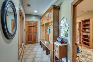 A hallway with a wooden door, a bench, and a wall-mounted mirror. - Pool, Hot Tub & Dock: Lake Hartwell Home (Anderson)