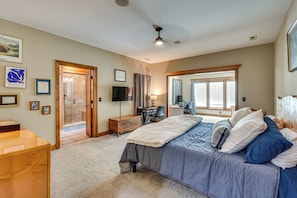 A bedroom with a bed, a desk, a TV, and a shower area. - Pool, Hot Tub & Dock: Lake Hartwell Home (Anderson)