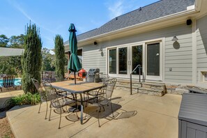 A patio with a table and chairs, a grill, and a pool. - Pool, Hot Tub & Dock: Lake Hartwell Home (Anderson)