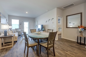A spacious living area with a dining table, chairs, a sofa, and a television. - 'Coastal Charm' Golf Getaway in Myrtle Beach (Myrtle Beach)
