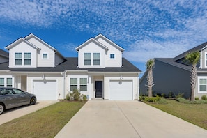 A two-story residential house with a garage, a driveway, and a lawn. - 'Coastal Charm' Golf Getaway in Myrtle Beach (Myrtle Beach)