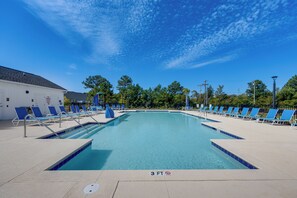 A clear blue swimming pool with blue lounge chairs and a white building in the background. - 'Coastal Charm' Golf Getaway in Myrtle Beach (Myrtle Beach)