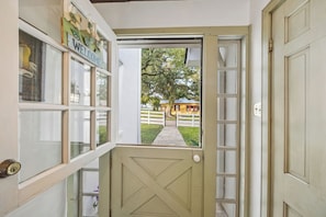 Un ingresso che dà su una proprietà con una porta bianca e una finestra con il cartello 'WELCOME'.