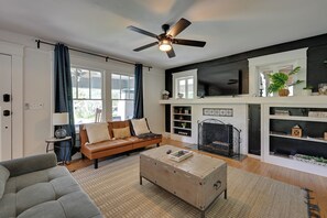 A living room with a sofa, coffee table, and fireplace. - 4BR Tampa Home, Easy Access to Dtwn (Tampa)