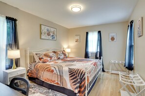 Ein Schlafzimmer mit Bett, Nachttisch, Lampe und einem kleinen Schreibtisch mit Stuhl.