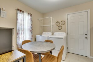 A compact living space with a round table and chairs, a washing machine, and a door with a white frame. - 5 Mi to Dtwn & Bricktown! Quaint Escape (Oklahoma City)