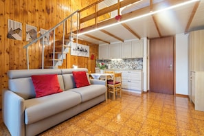 A wooden interior with a sofa, dining table, and kitchen area. - Mountain Nest - Netflix - Pet Friendly - Parking (Tarvisio)