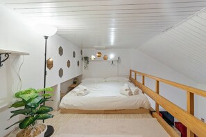 A bedroom with a wooden bed frame, a bedside table, a lamp, and a potted plant. - Mountain Nest - Netflix - Pet Friendly - Parking (Tarvisio)