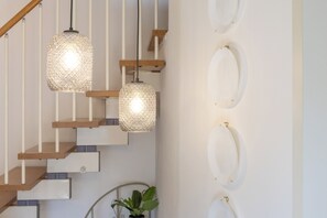 A staircase with wooden steps and metal railings, two hanging pendant lights, and three wall-mounted lights. - Casa Giulia - con Parcheggio Privato e Terrazza (Gorizia)
