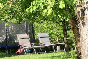 Two lounge chairs under a tree in a grassy area. - Wiesholler Guest and Apartment House (Chieming)