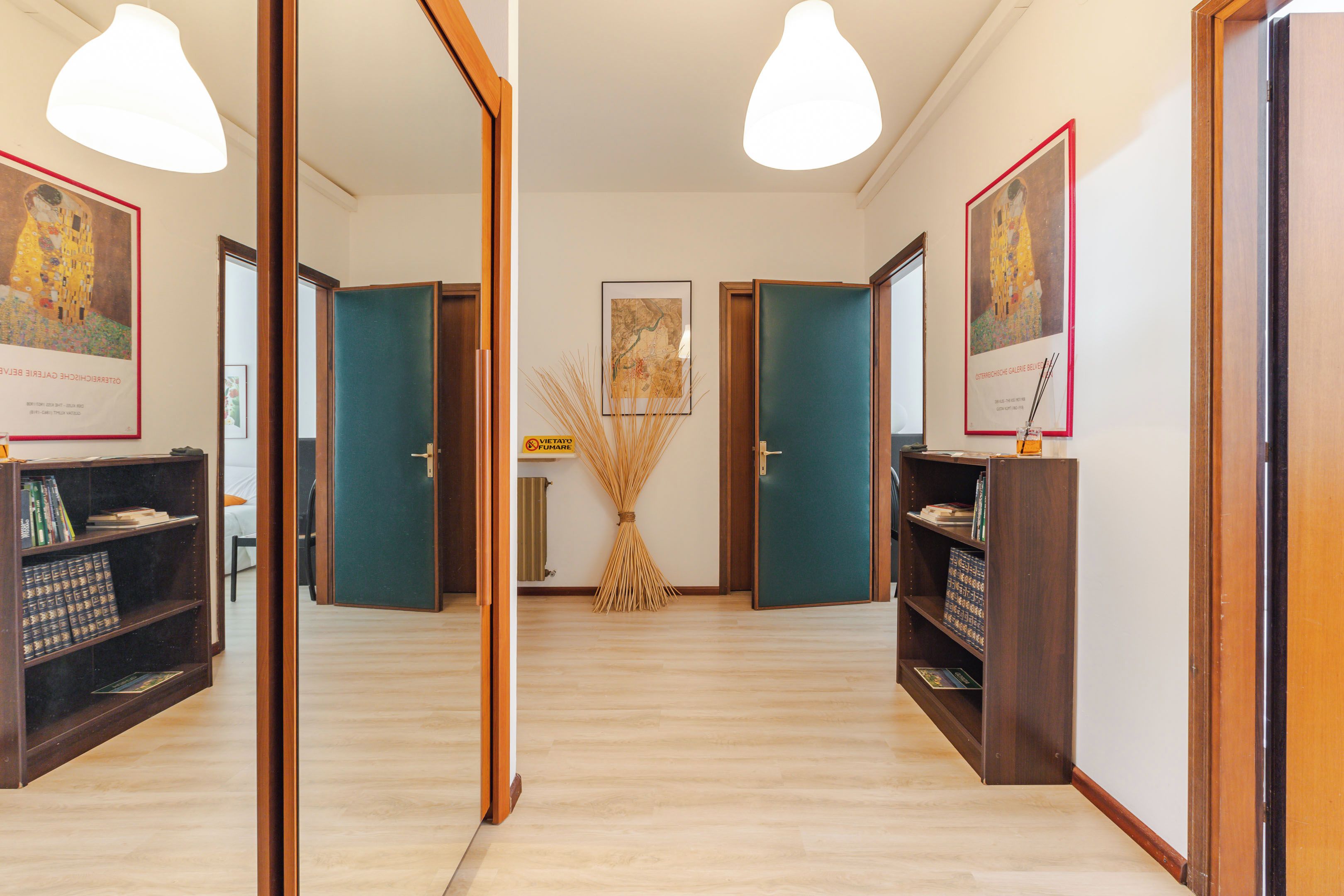 A hallway with wooden doors, a central table with a map, and framed artwork on the walls.