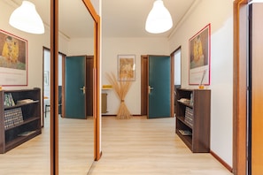 Un pasillo con puertas de madera, una mesa central con un mapa y obras de arte enmarcadas en las paredes.