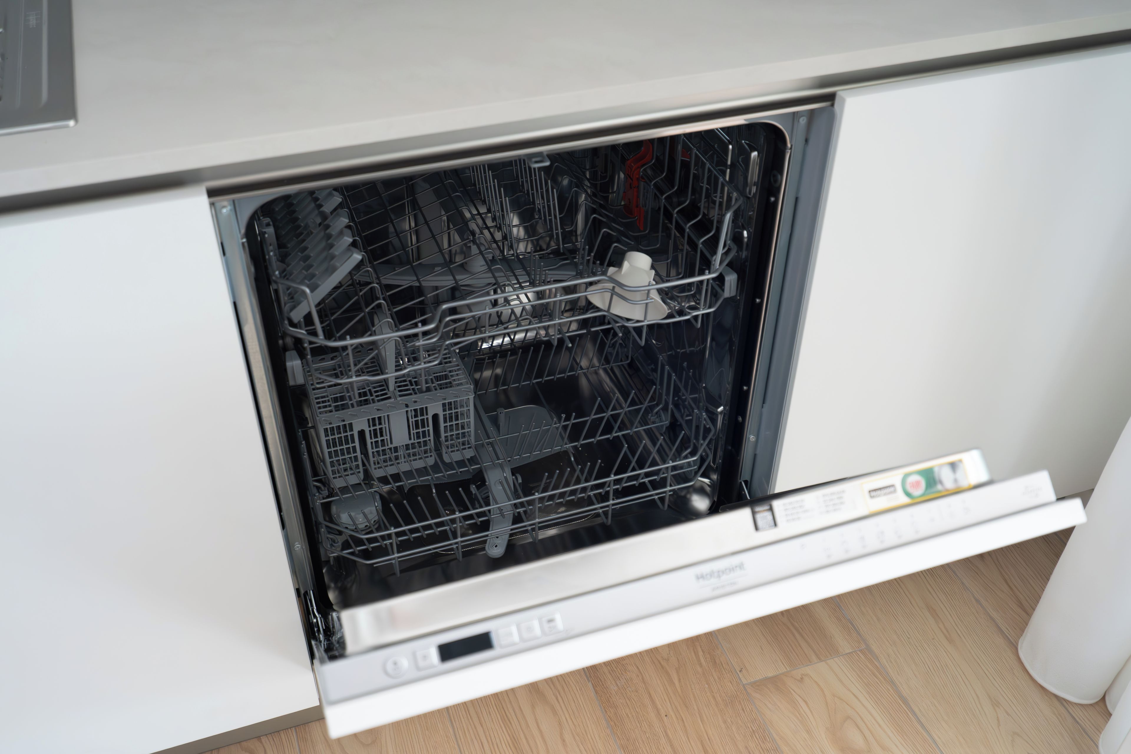 En diskmaskin med öppen lucka, en kontrollpanel och en vit interiör.
