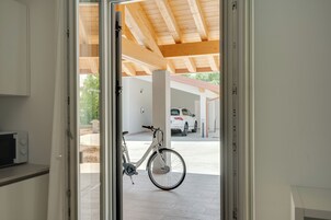 Una bicicleta estacionada dentro de un edificio, con vista a un área de estacionamiento.