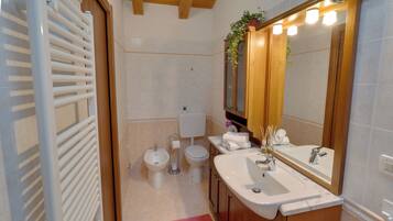 Un baño con bañera, dos lavamanos, inodoro y bidé.