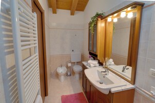 Un baño con bañera, dos lavamanos, inodoro y bidé.