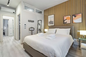 Et hotelværelse med en stor seng, en trævægsbeklædning og kunstværker.