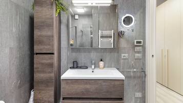 Een moderne badkamer met een houten wastafel, een grote spiegel, een ingebouwde verwarming en een toilet.