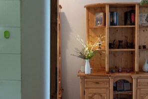 A wooden cabinet with books and decorative items. - Wooden Stories - Netflix, Wi-fi, Pet Friendly (Socchieve)