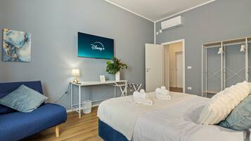Ein modernes Hotelzimmer mit einem Bett, einem Schreibtisch, einem Fernseher und einem Kleiderschrank.