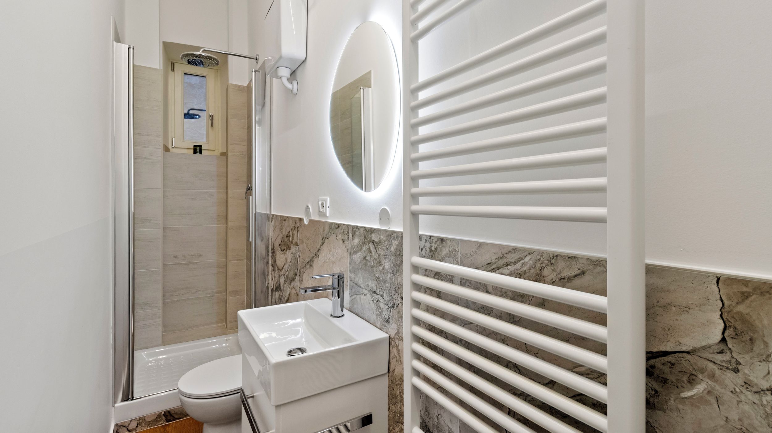 A modern bathroom with a shower, toilet, and sink.