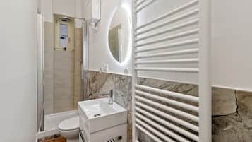 A modern bathroom with a shower, toilet, and sink.