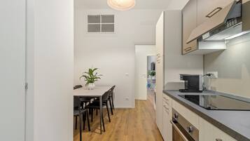 Eine moderne Küche mit Essbereich, Holzboden und einem Blumentopf.