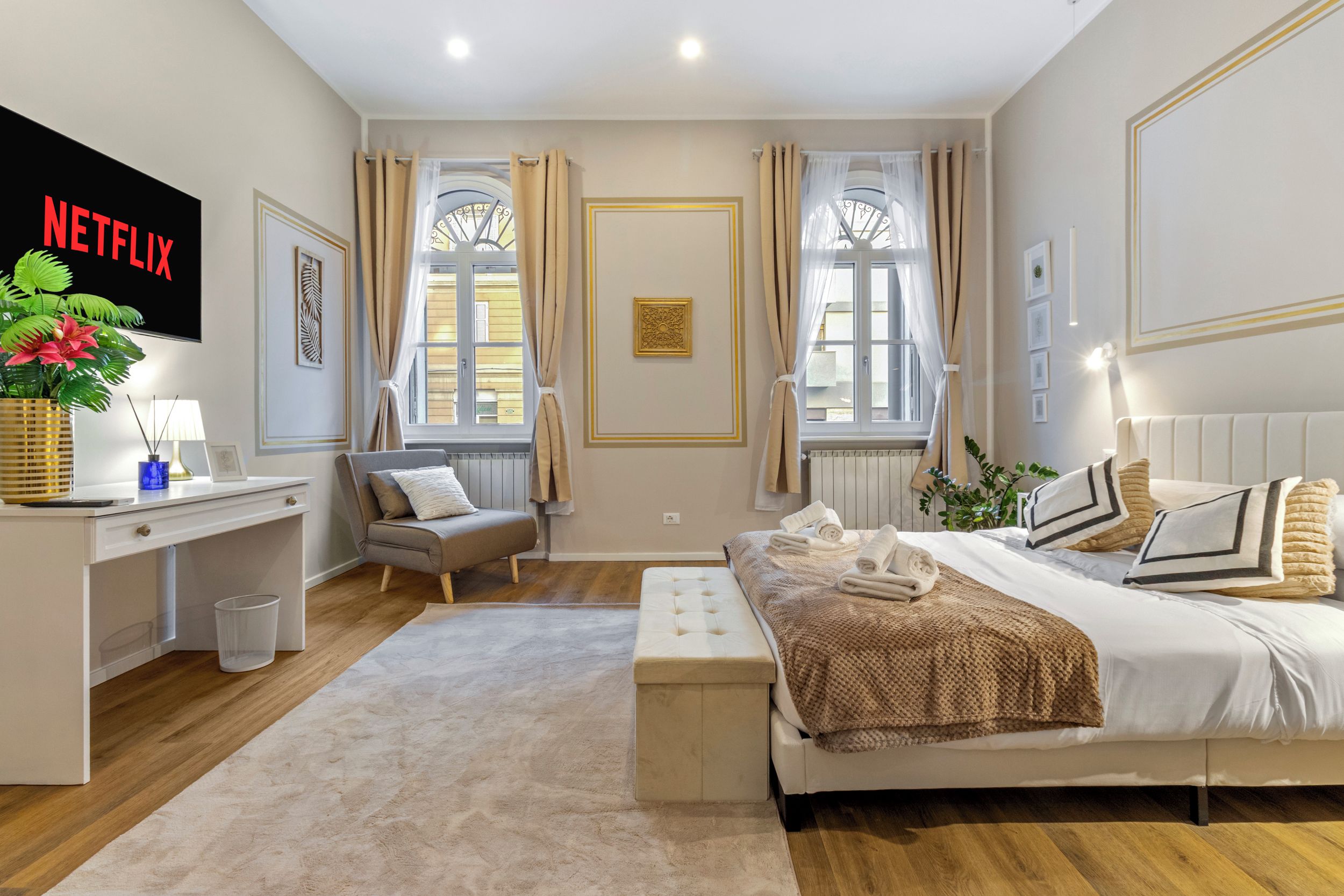 Habitació d'hotel amb un llit, un escriptori, una cadira, un televisor i una finestra.