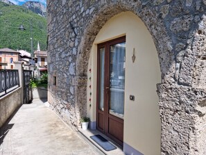 A stone building with a wooden door and a small potted plant.