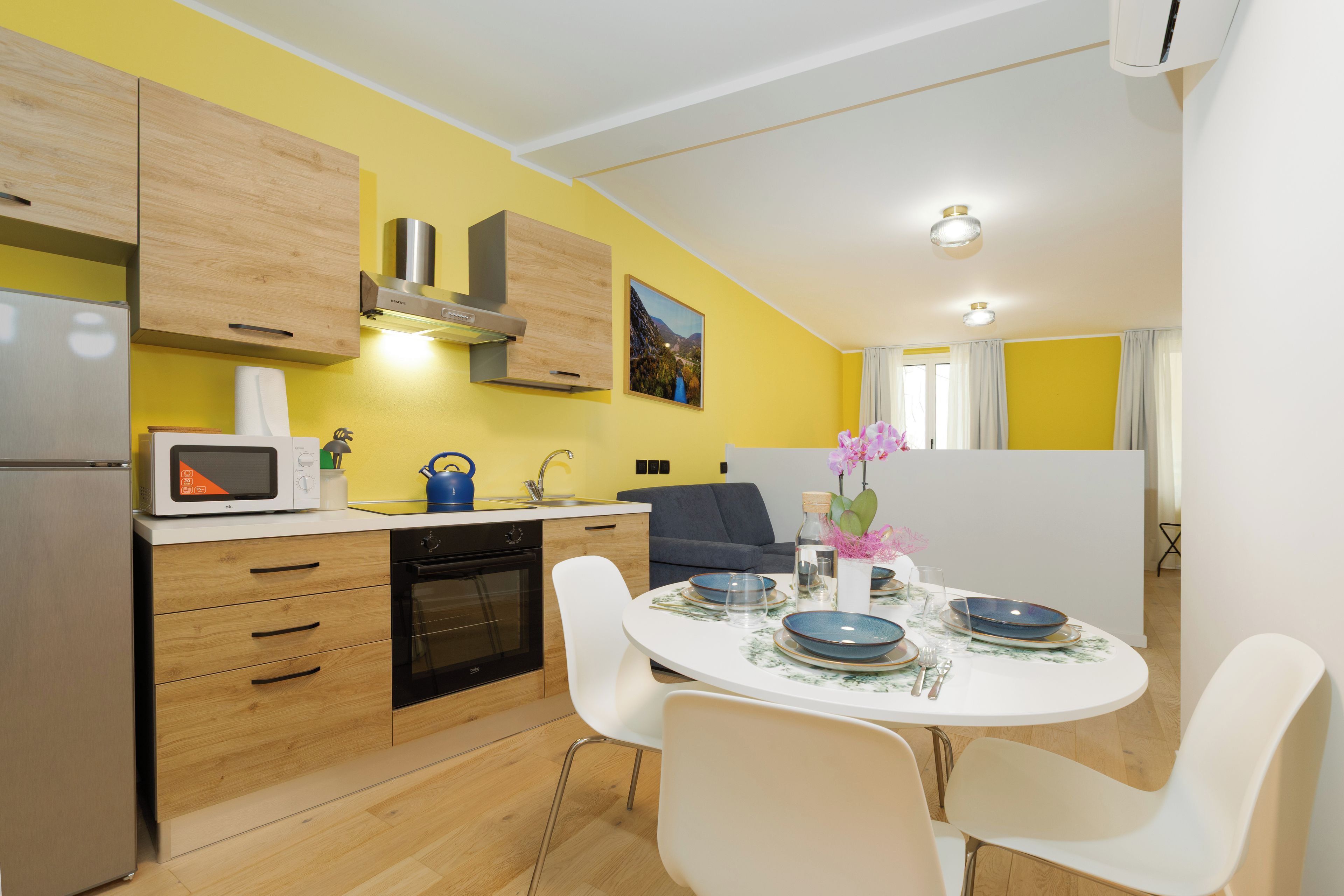 Una cucina moderna con mobili in legno, forno integrato e microonde.
